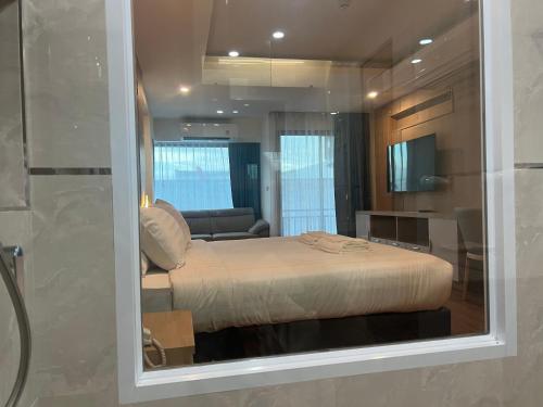 a bedroom with a bed and a glass window at The Square Hotel เดอะสแควร์โฮเทลนครพนม in Nakhon Phanom