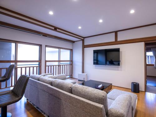 a living room with a couch and a flat screen tv at Norichanchi in Nozawa Onsen