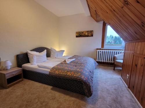 una camera da letto con un letto con cuscini bianchi e una finestra di Ferienhaus Regner „Das Anwesen am See“ **** a Feldberg