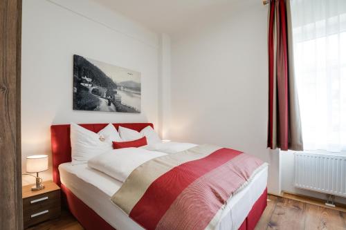 Schlafzimmer mit einem roten und weißen Bett und einem Fenster in der Unterkunft Konrad-Haus - DorfResort Mitterbach in Mitterbach