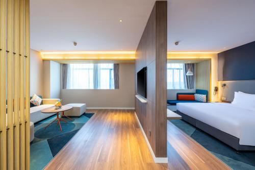 una camera d'albergo con letto e divano di Holiday Inn Express Xinji City Center, an IHG Hotel a Xinji