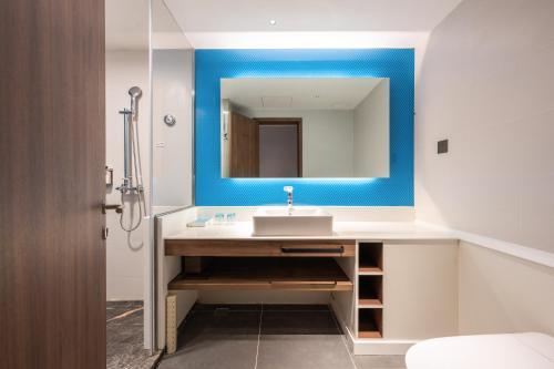 W łazience znajduje się umywalka i lustro. w obiekcie Holiday Inn Express Xinji City Center, an IHG Hotel w mieście Xinji