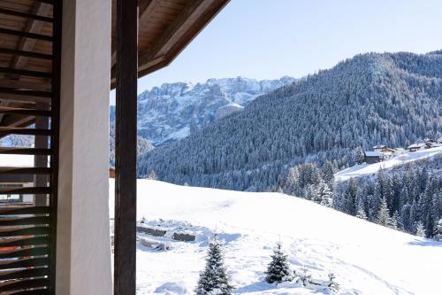 a room with a view of a snow covered mountain at Villa Carolina in Selva di Val Gardena