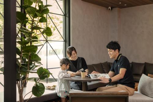 a family sitting around a coffee table in a living room at Hotel Ten to Ten in Sapporo