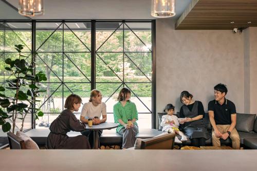 a group of people sitting around a table in a room at Hotel Ten to Ten in Sapporo