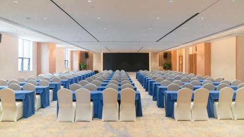 a conference room with blue tables and chairs and a screen at Holiday Inn Express Nanning Jiangnan by IHG in Nanning