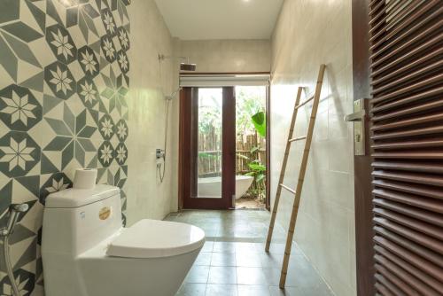 a bathroom with a toilet and a ladder in it at An Bang Seastar Boutique Villa in Hoi An