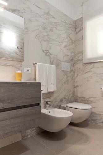 a bathroom with a sink and a toilet and a mirror at Kalsa Sicilian Rooms in Partinico
