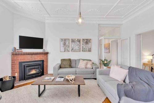a living room with a couch and a fireplace at Currawong Bungalow - An Idyllic Group Stay in Town in Mudgee