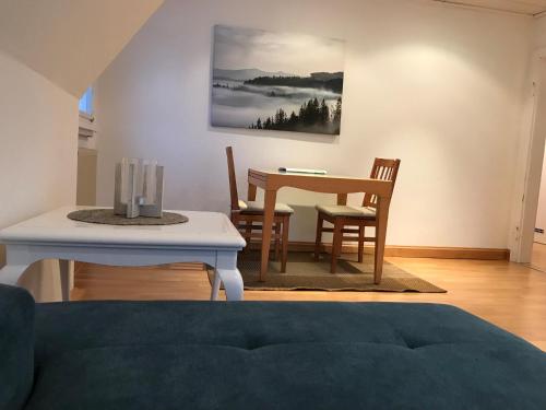 sala de estar con mesa de comedor, mesa y sillas en Generations Holiday City Flat en Attendorn