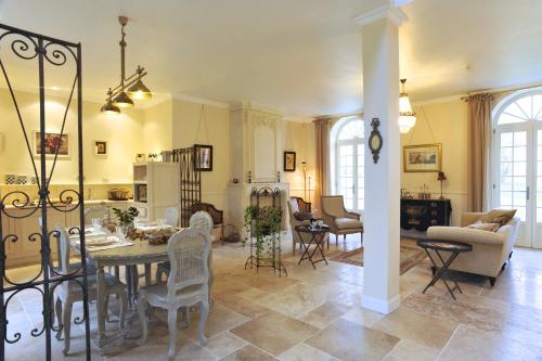 Un comedor y una sala de estar con mesa y sillas. en L'Orangerie du Grand Jardin, en Condé-sur-Seulles