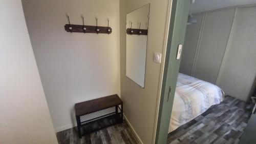 een kleine kamer met een bed en een spiegel bij Chambre privée in Le Bugue