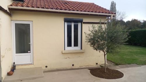 un petit arbre devant une maison avec une porte dans l'établissement Chambre privée, au Bugue