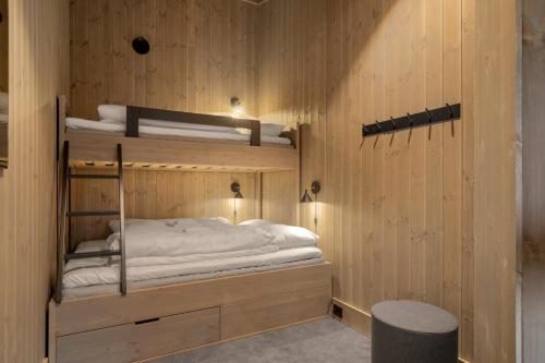 a room with two bunk beds in a wooden wall at Yttersvingen Kvitfjell in Kvitfjell