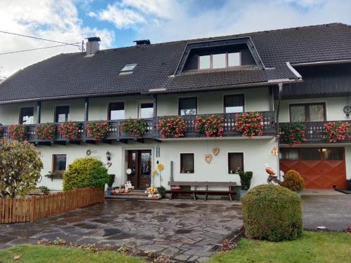 una grande casa bianca con fiori sul balcone di Ferienwohnung Haus Gatternig a Seeboden