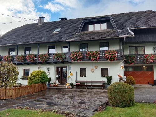 a large white house with flowers on the balcony at Ferienwohnung Haus Gatternig in Seeboden