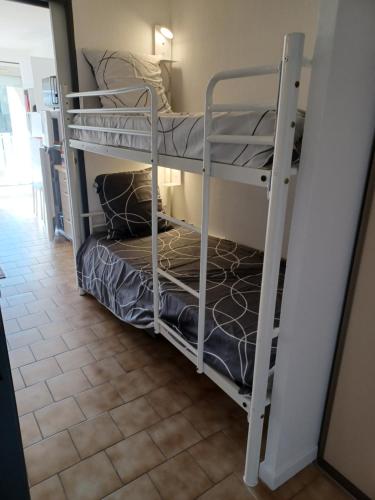 2 stapelbedden in een kamer met een tegelvloer bij Charmant appart. 500m plages des Sablettes in La Seyne-sur-Mer