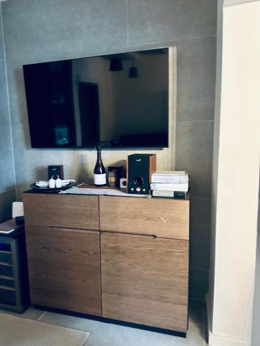 a large wooden dresser with a television on a wall at STONE Apartment in Žilina