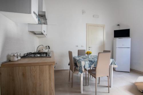 a kitchen and dining room with a table and chairs at Bed&Dreams in Salento - Bilocale deluxe con vasca idromassaggio in Guagnano