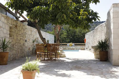 a patio with two chairs and a tree at Villa Praxithea BY APOKORONAS-VILLAS in Gavalochori