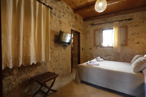 a bedroom with a bed and a television and a window at Villa Praxithea BY APOKORONAS-VILLAS in Gavalochori
