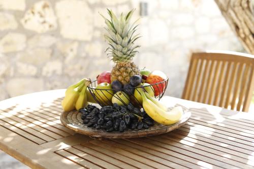 a plate of fruit on a table with a pineapple at Villa Praxithea BY APOKORONAS-VILLAS in Gavalochori