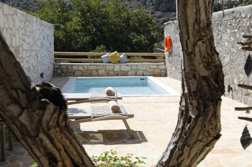 a pool with a bench and a chair in a yard at Villa Praxithea BY APOKORONAS-VILLAS in Gavalochori