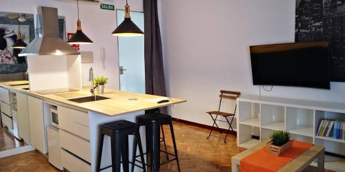 a kitchen with a counter and a kitchen island with stools at ALMAALQUILER Gran Maestre 3 in Almagro