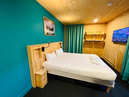 a bed in a room with a blue wall at The People - Les 2 Alpes in Les Deux Alpes