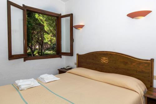 een slaapkamer met 2 bedden en een raam bij Baia Delle Palme Beach in Santa Margherita di Pula