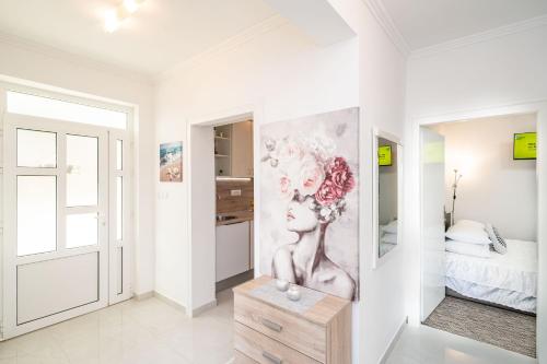 a white room with a painting on the wall at Apartments Blažević in Mlini