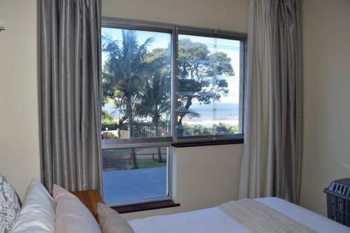 a bedroom with a large window with a view of the ocean at Apartment with Sea View at Margate, South Coast in Margate