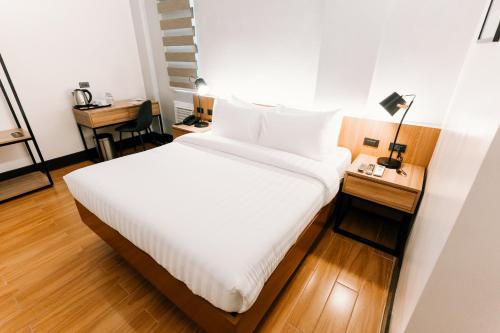 a bedroom with a bed and a table with a lamp at El Sancho Hotel in Naga