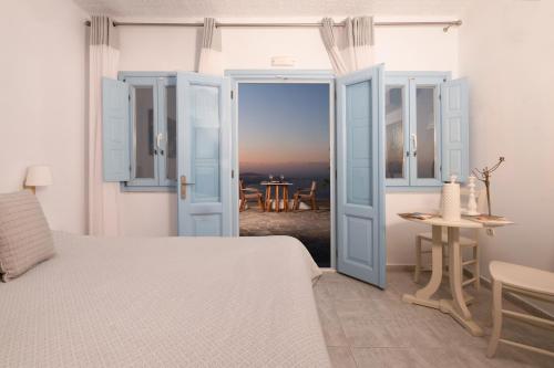 a bedroom with a bed and a view of a table at Andromeda Villas & Spa Resort in Imerovigli