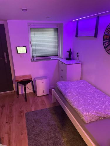 Un dormitorio con una habitación púrpura con una cama y una mesa en sweet Lounge international TV Netflix WIFI, en Ehringshausen