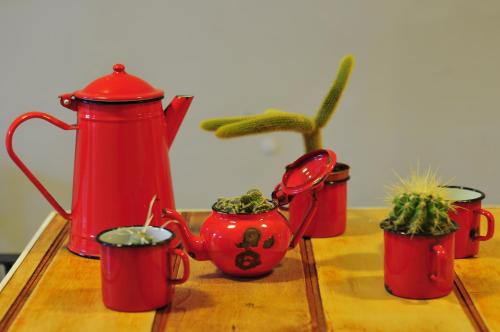 a group of red tea pots with plants in them at The Bellini House by House In Naples in Naples