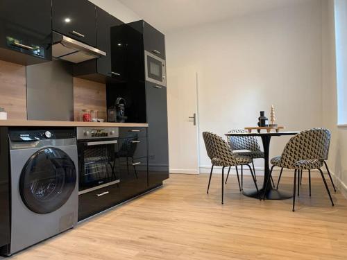 a kitchen with a table and a table and chairs at Appartement chaleureux in Dijon