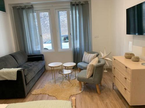 a living room with a couch and two chairs and a table at Appartement chaleureux in Dijon