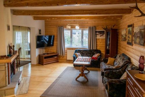 a living room with a couch and a tv at Beskidzki Klimat Jaśliska in Jaśliska