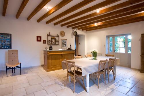 une cuisine et une salle à manger avec une table et des chaises dans l'établissement B&B La Cerisaie, à Francheleins