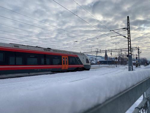 a red and white train on the tracks in the snow at Lillehammer Stasjonen Hotel in Lillehammer