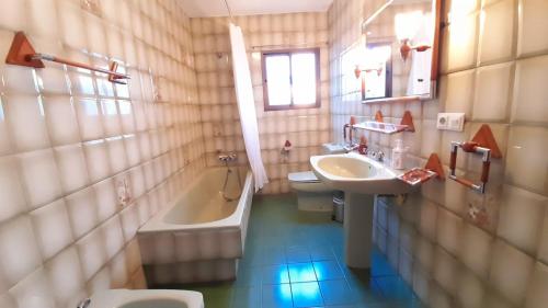 een badkamer met een wastafel, een bad en een toilet bij Casa Rural Doña Catalina in Jimena de la Frontera