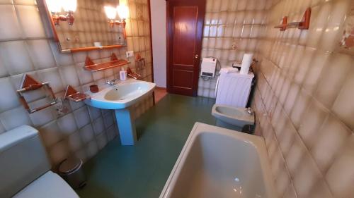 een badkamer met een wastafel, een toilet en een bad bij Casa Rural Doña Catalina in Jimena de la Frontera
