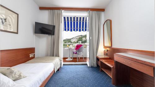 a hotel room with two beds and a window at Hotel Komodor in Dubrovnik