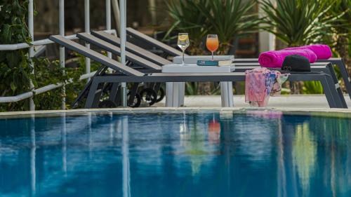 a table with a glass of wine next to a swimming pool at Hotel Komodor in Dubrovnik
