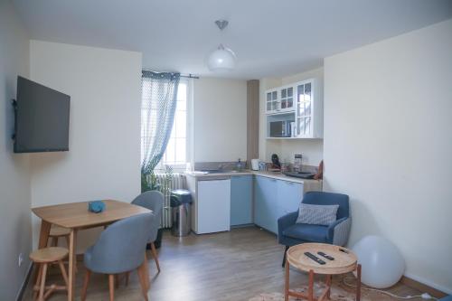 een woonkamer met een keuken en een tafel en stoelen bij CROIX BLANCHE - LE LOGIS in Tournan-en-Brie