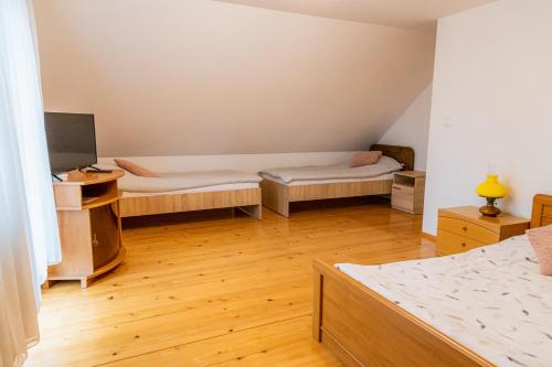 a room with two beds in a room with wooden floors at Beskidzki Klimat Jaśliska in Jaśliska