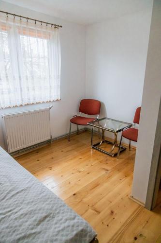 a bedroom with a bed and two chairs and a glass table at Beskidzki Klimat Jaśliska in Jaśliska