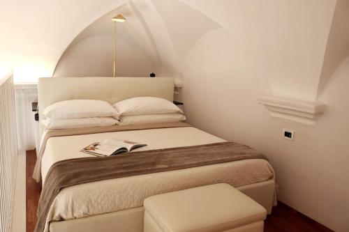 a bedroom with a large bed with a white headboard at kaDevi piazza Bresca - pieno centro, parcheggio, bici in Sanremo