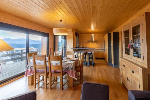 une cuisine et une salle à manger avec une table et des chaises dans l'établissement Adret - apt avec terrasse, aux Angles